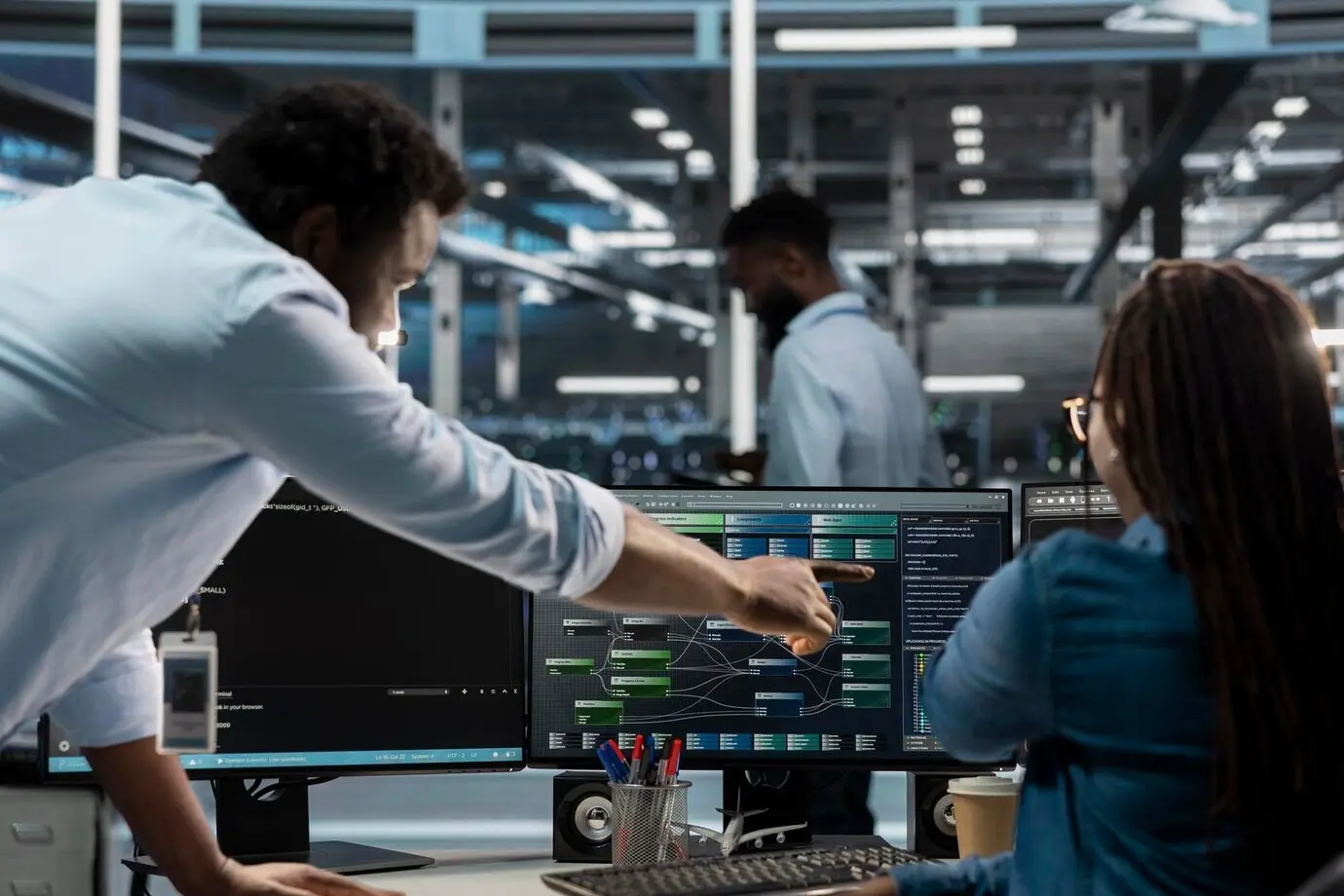 Supervisor del centro de datos supervisando a un administrador que utiliza una PC para visualizar árboles de nodos de IA.